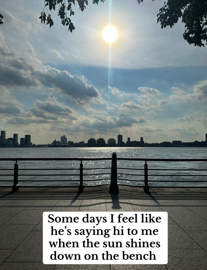 A photo of a sunrise over New Jersey from the POV of a memoral bench