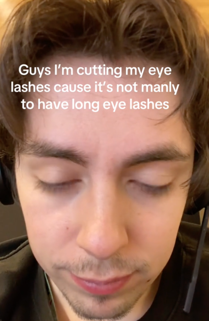 A man contemplating cutting lashes because they aren't manly