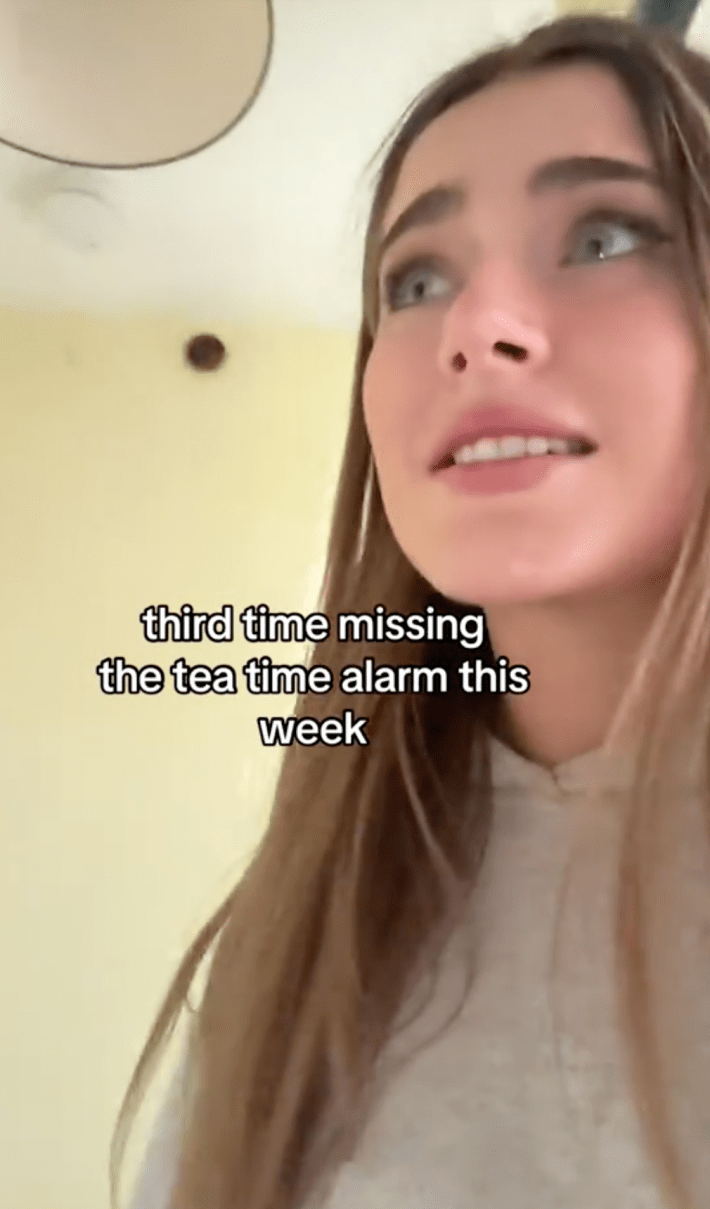 A woman running around during british tea time alarm, worried she's going to be fined