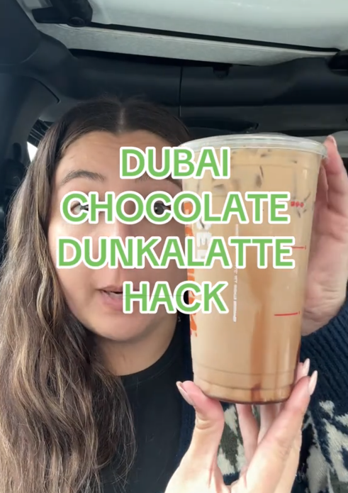 TikTok video of a woman holding up a drink under the words "Dubai chocolate Dunkalatte hack."