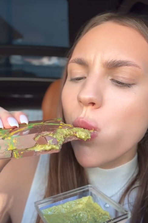 TikTok video of a woman eating a chocolate bar.