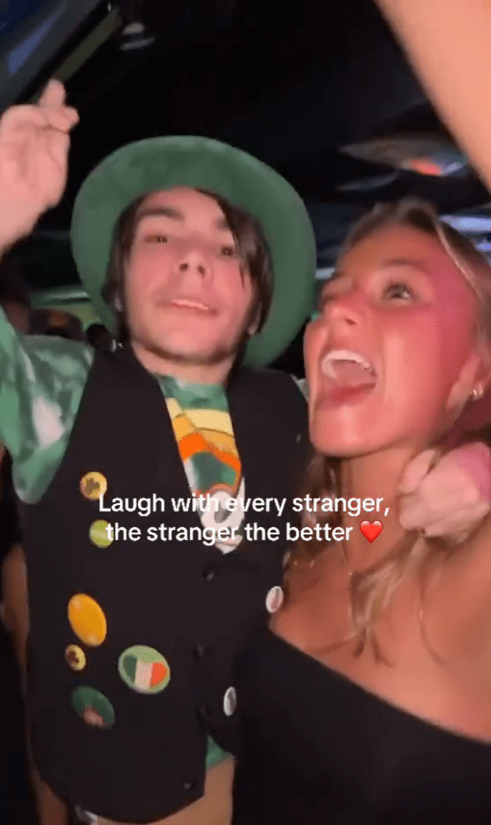 Laugh with every stranger trend, a girl holding a little man in her arms who is dressed like a leprechaun.