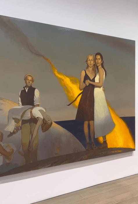 Instagram video showing a painting of two women holding each other next to a man carrying a body in his arms.