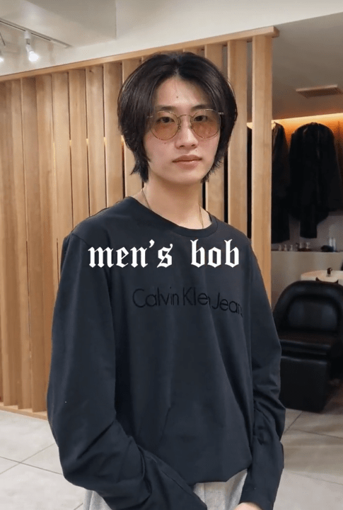 TikTok video showing a man in glasses with a layered men's bob.