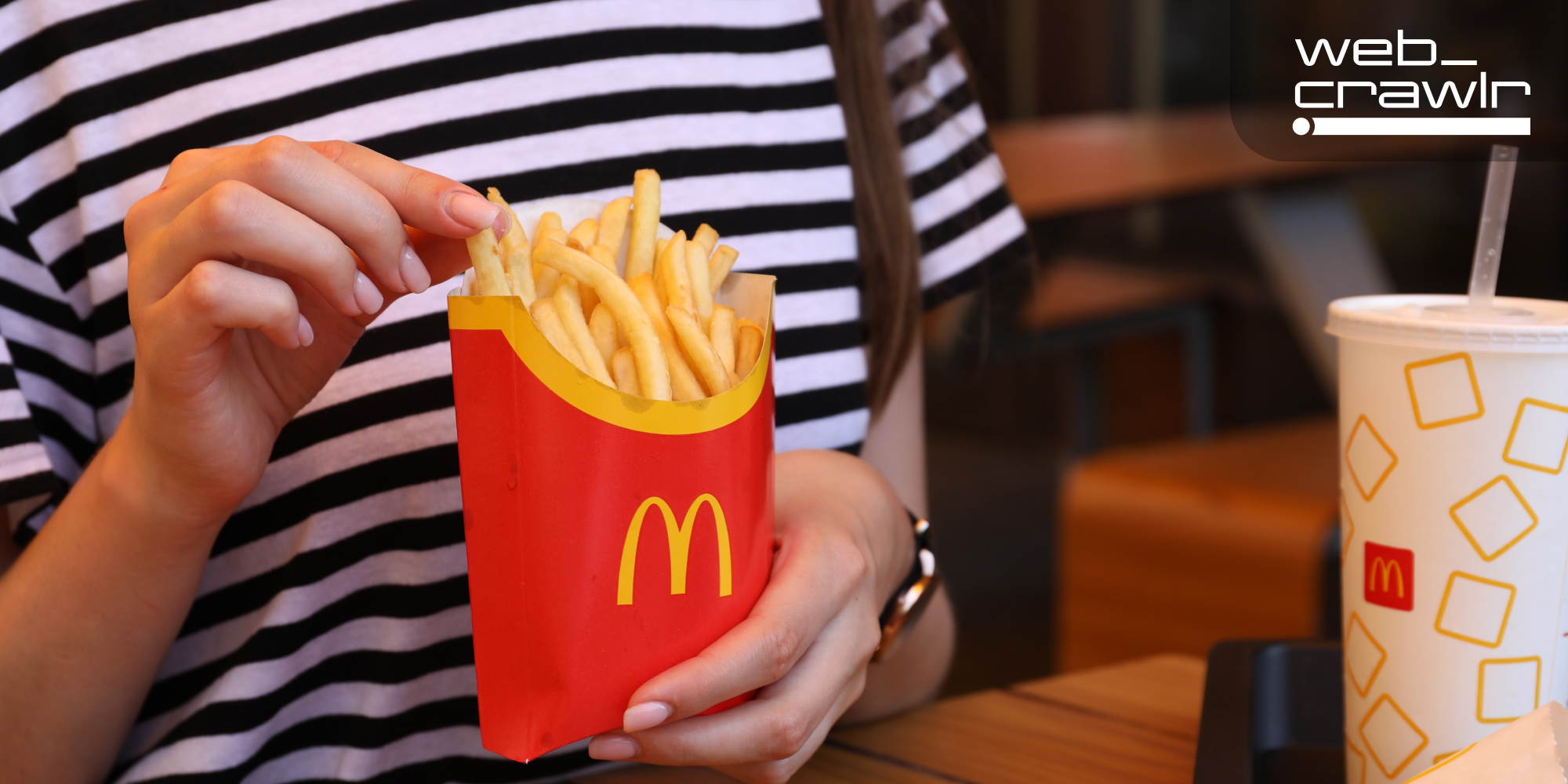 A person eating McDonald's fries. The Daily Dot newsletter web_crawlr logo is in the top right corner.