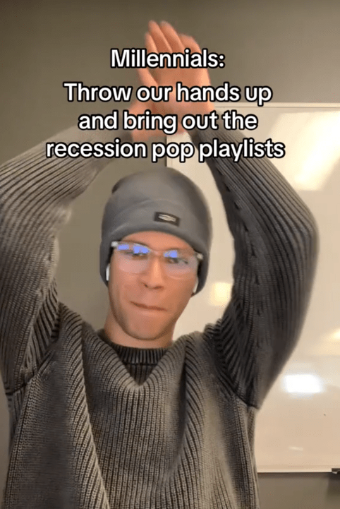 A man in a gray sweater with his hands in the air under the caption "Millennials: Throw our hands up and bring out the recession pop playlists."