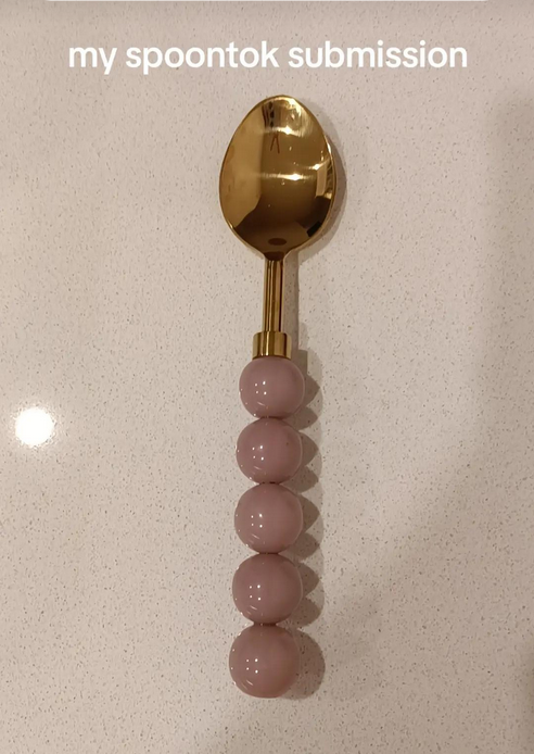 Spoontok spoon rating video showing a gold spoon with a pink beaded handle.