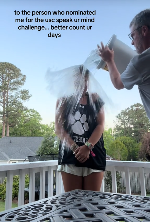 TikTok video of a woman getting splashed with a bucket of water on a deck with a caption reading "to the person who nominated me for the usc speak your mind challenge... better count your days."