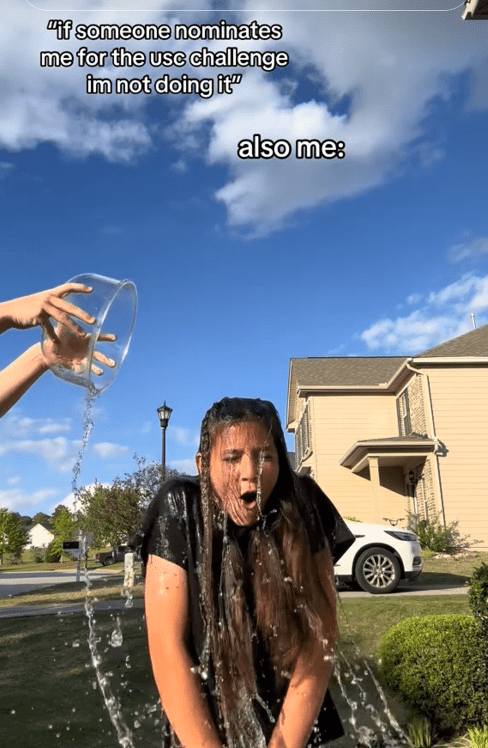TikTok video of a woman getting splashed with water in a yard with a caption reading "'if someone nominates me for the usc challenge im not doing it' also me:"