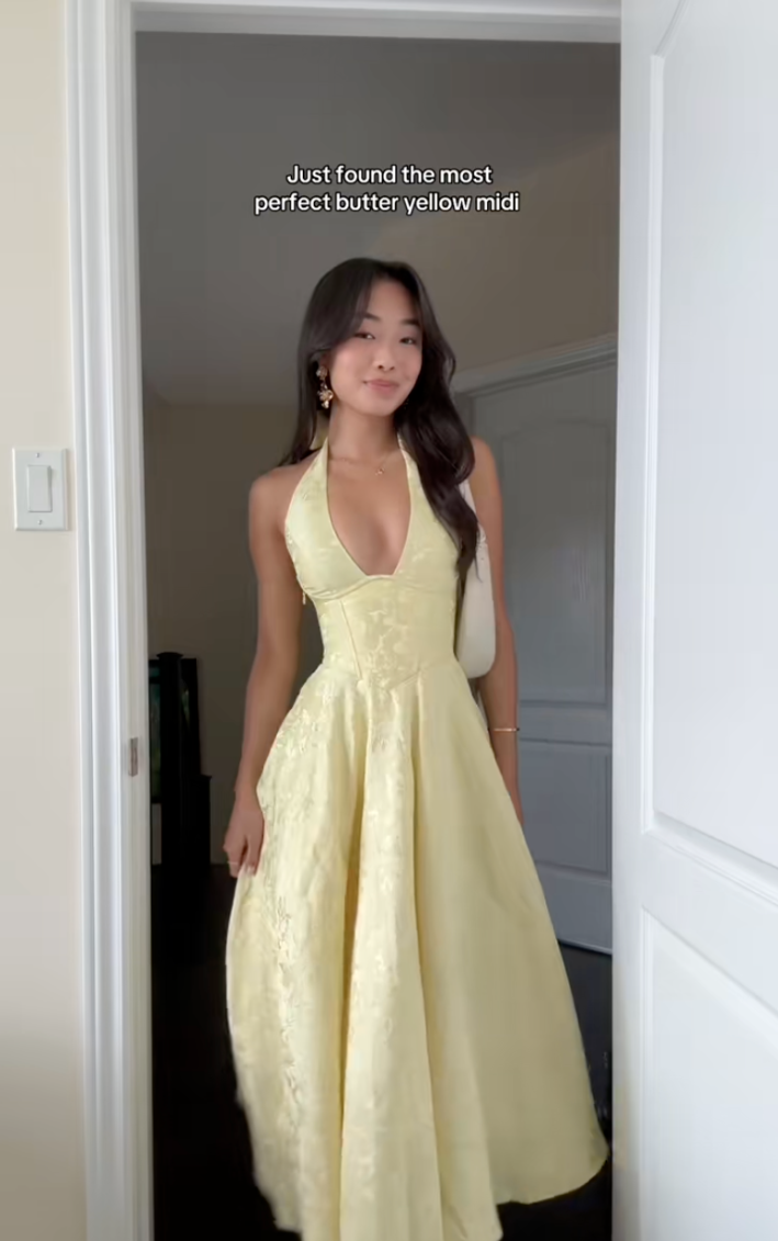 An Asian woman in a butter yellow sun dress. Text overlay reads, "Just found the most perfect butter yellow midi."