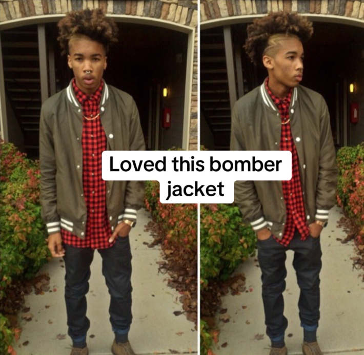 A boy with a partially shaved afro and bomber jacket posing for the camera.