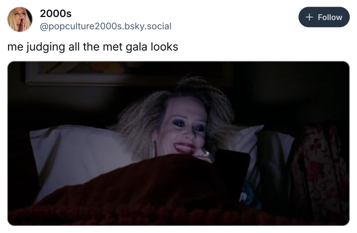 Post that reads, "me judging all the met gala looks" with a photo of a woman in bed in the dark looking at her phone and grinning.