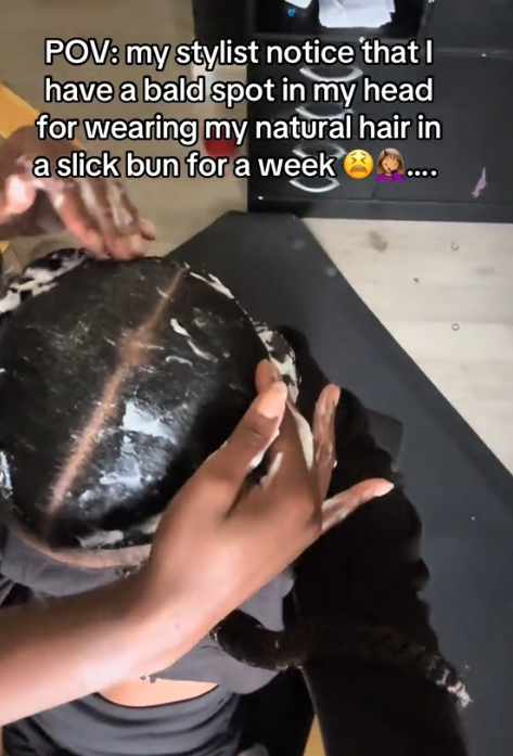 Slicked back bun traction alopecia TikTok video with a stylist showing a bald spot in a woman's part.