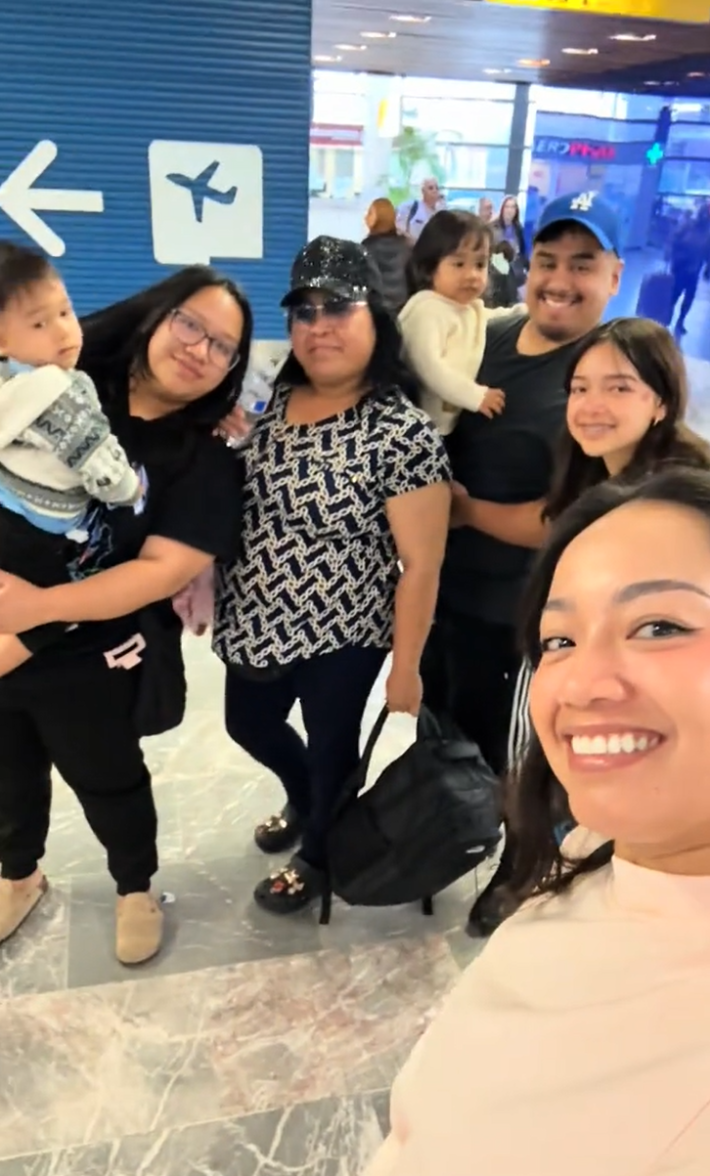 View of the whole family at the airport in Tijuana, Mexico. Everyone is smiling for the camera.