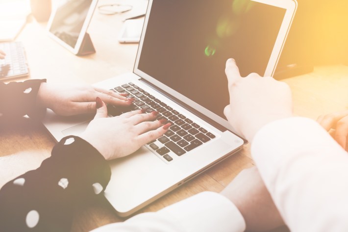 Man mentoring in discussion with female coworker in small office