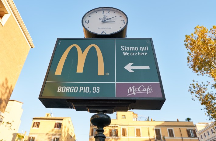 a sign showing the direction of the fast-food McDonald's restaurant in Rome