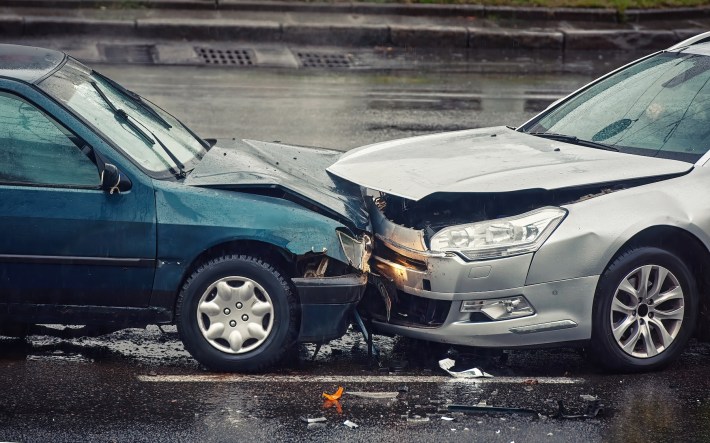 Car accident on wet road during rain, head on collision side view