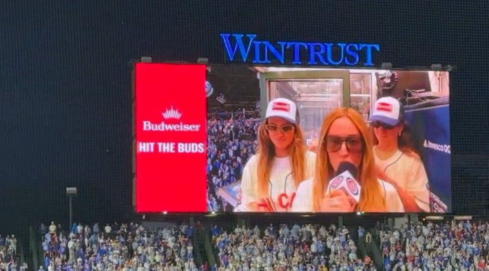 Video of the big screen at Wrigley Field, with Alex Cooper and backup dancers on screen.