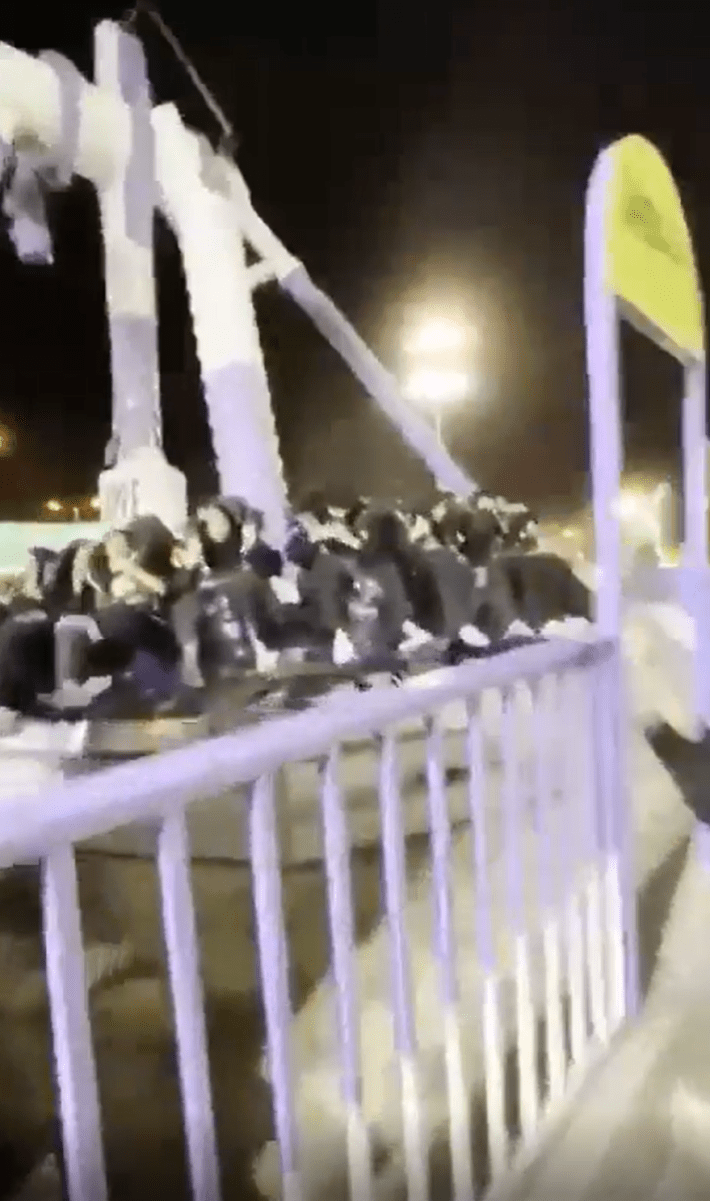Screenshot of a broken amusement park ride, the riders still in their seats after falling.