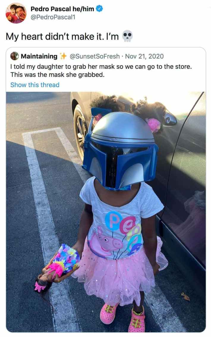 An adorable girl wearing a Mandalorian helmet instead of a face mask. Pascal QRTed saying, "My heart didn't make it. I'm (skull emoji)"