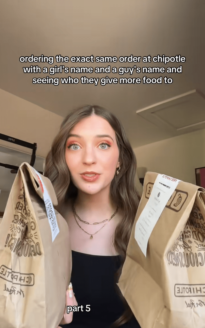 A woman holding up two takeout bags. Text reads, "ordering the exact same order at chipotle with a girl's name and a guy's name and seeing who they give more food to."
