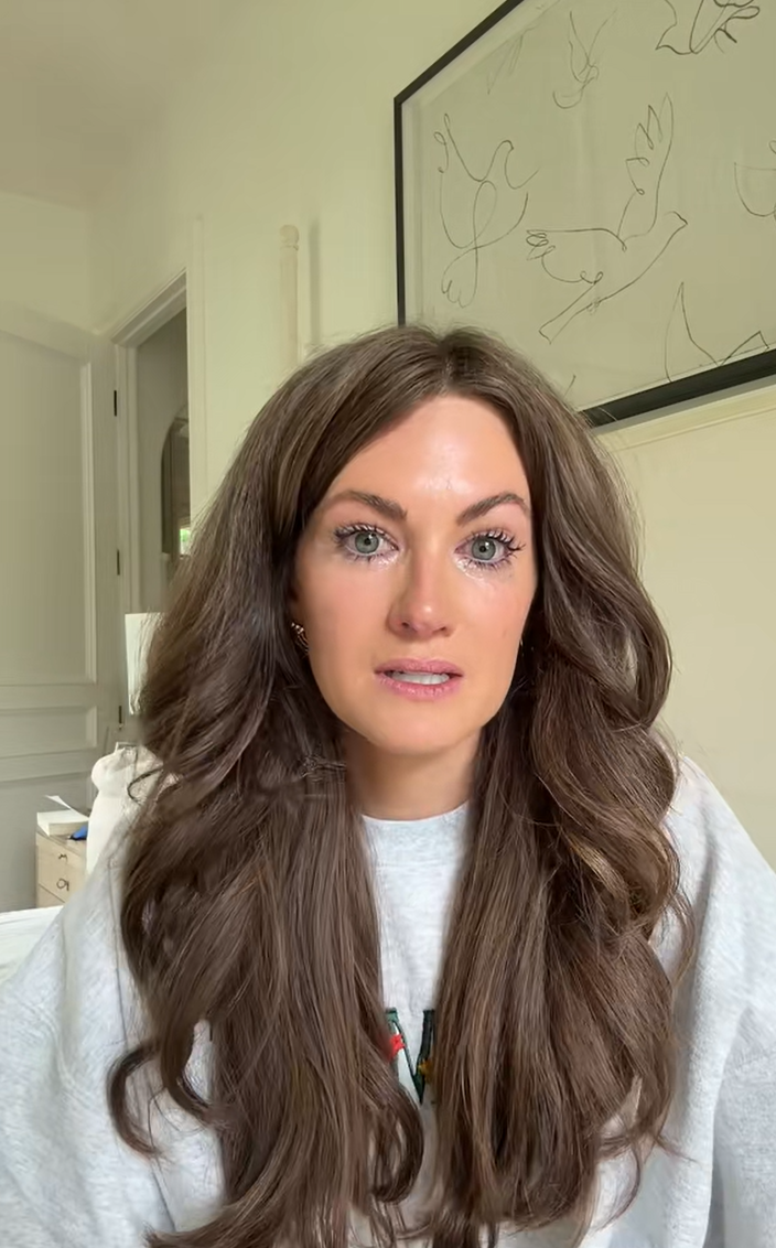 A tearful woman with perfect hair looking at the camera.