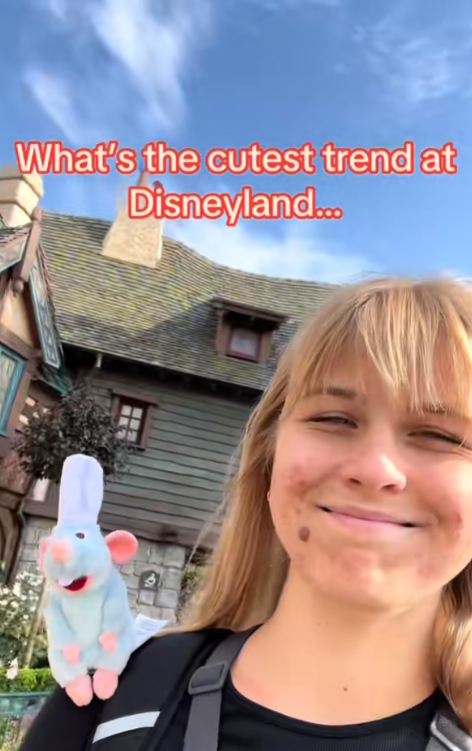 A person smiling for the camera with a Remy rat on their shoulder. Text overlay reads, "What's the cutest trend at Disneyland..."