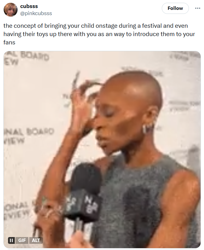 Tweet reading "the concept of bringing your child onstage during a festival and even having their toys up there with you as an way to introduce them to your fans" with a gif of a woman touching her head.