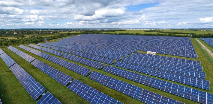 Aerial view of large sustainable electrical power plant with rows of solar photovoltaic panels for producing clean electric energy