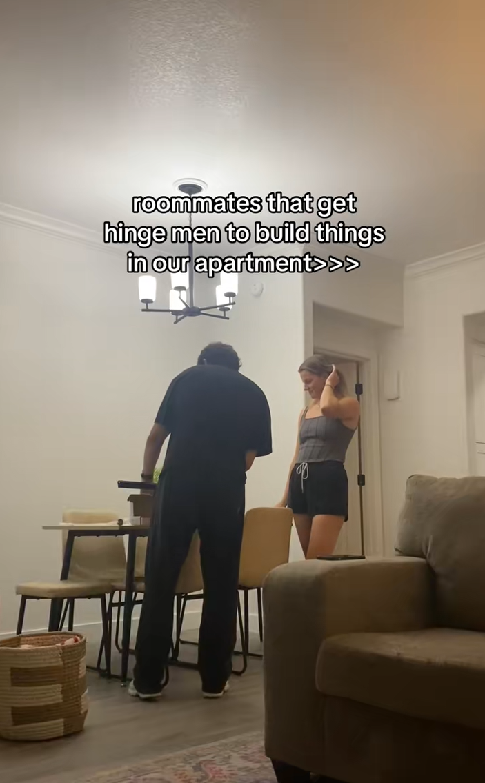 A woman and man working on building something on a table. Text overlay reads, "roommates that get hinge men to build things in our apartment>>>"
