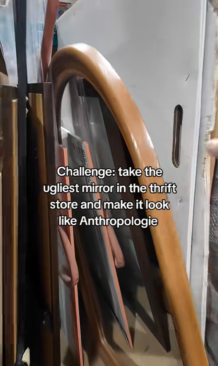 A stack of mirrors in a thrift store. Text reads, "Challenge: take the ugliest mirror in the thrift store and make it look like Anthropologie."