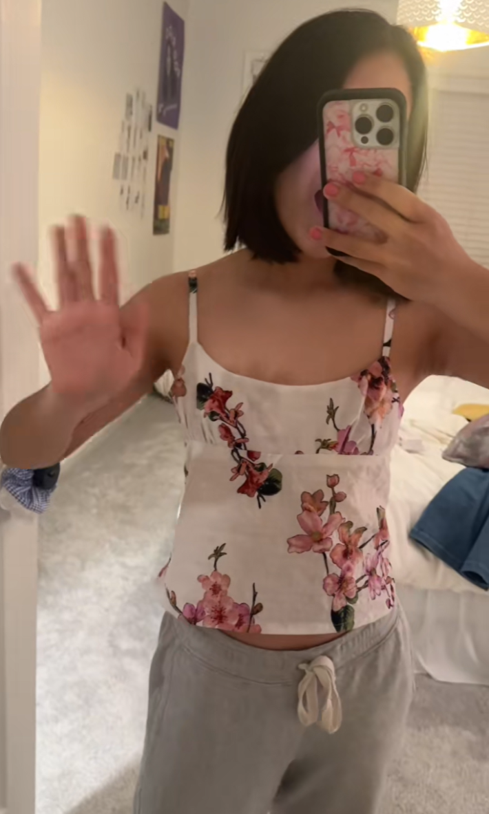 Person showing off the updated floral top, now a strappy tank top.