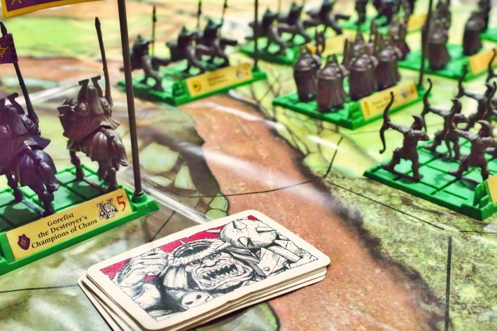 Close-up of Battle Masters strategy board game with playing cards and plastic model miniature fantasy soldiers