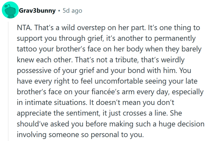 Reddit comment reading "NTA. That’s a wild overstep on her part. It’s one thing to support you through grief, it’s another to permanently tattoo your brother’s face on her body when they barely knew each other. That’s not a tribute, that’s weirdly possessive of your grief and your bond with him. You have every right to feel uncomfortable seeing your late brother’s face on your fiancée’s arm every day, especially in intimate situations. It doesn’t mean you don’t appreciate the sentiment, it just crosses a line. She should’ve asked you before making such a huge decision involving someone so personal to you."