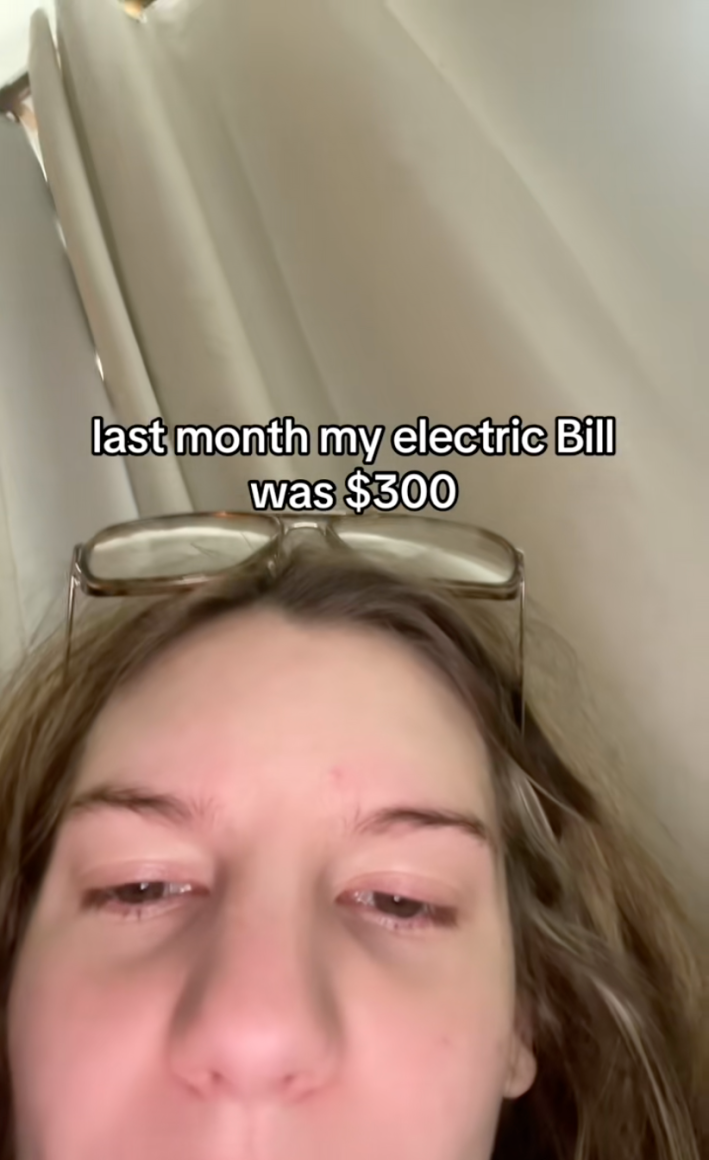 Woman staring down at the camera. Text overlay reads, "last month my electric bill was $300."