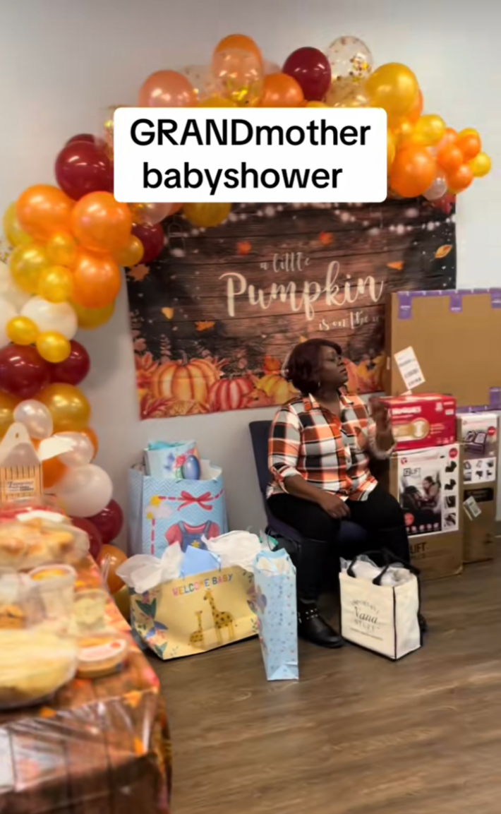 Video of a pumpkin-themed "GRANDmother baby shower" with a woman, presumably the grandma to be, surrounded by presents.