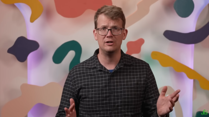 Hank Green on the SciShow, gesturing while he speaks.