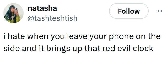 Tweet reading "i hate when you leave your phone on the side and it brings up that red evil clock"