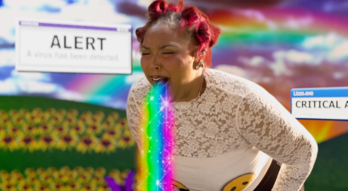 still from Lizzo music video "STFU" Lizzo vomiting a rainbow.