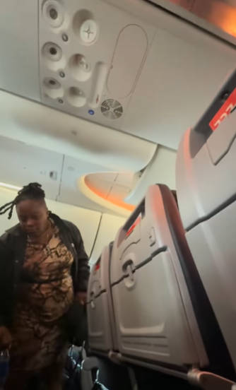 The unruly passenger gathering her belongings to leave the airplane.