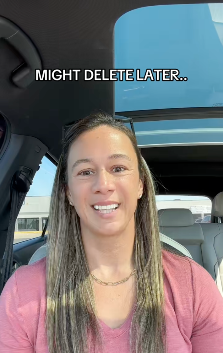 Woman in a car smiling with a pained expression at the camera. Text overlay reads, "Might delete later..."