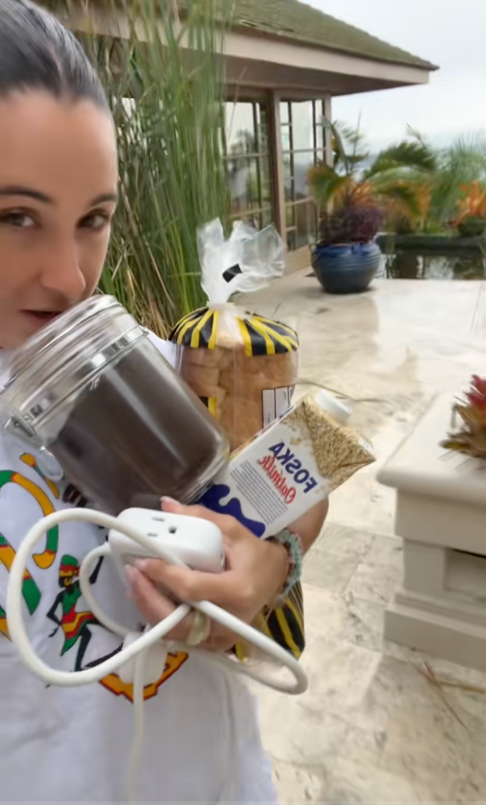 A woman carrying food, coffee grounds, and extension cords to the hurricane shelter.