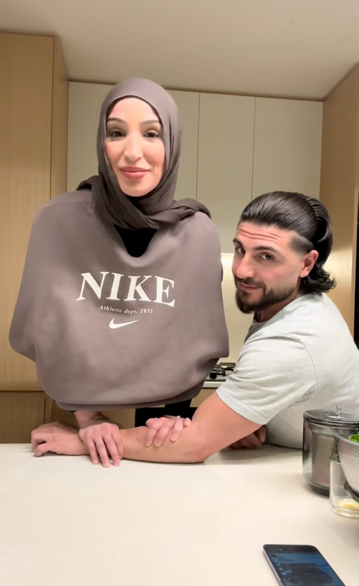 A couple doing the bird trend in a kitchen.