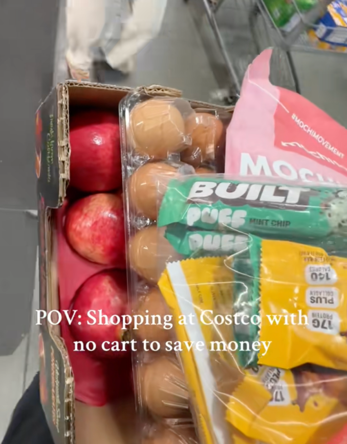 @the.hoang.family/TikTok shopping at costco without a cart - items placed into cardboard flat with onscreen text "POV: shopping at Costco with no cart to save money."