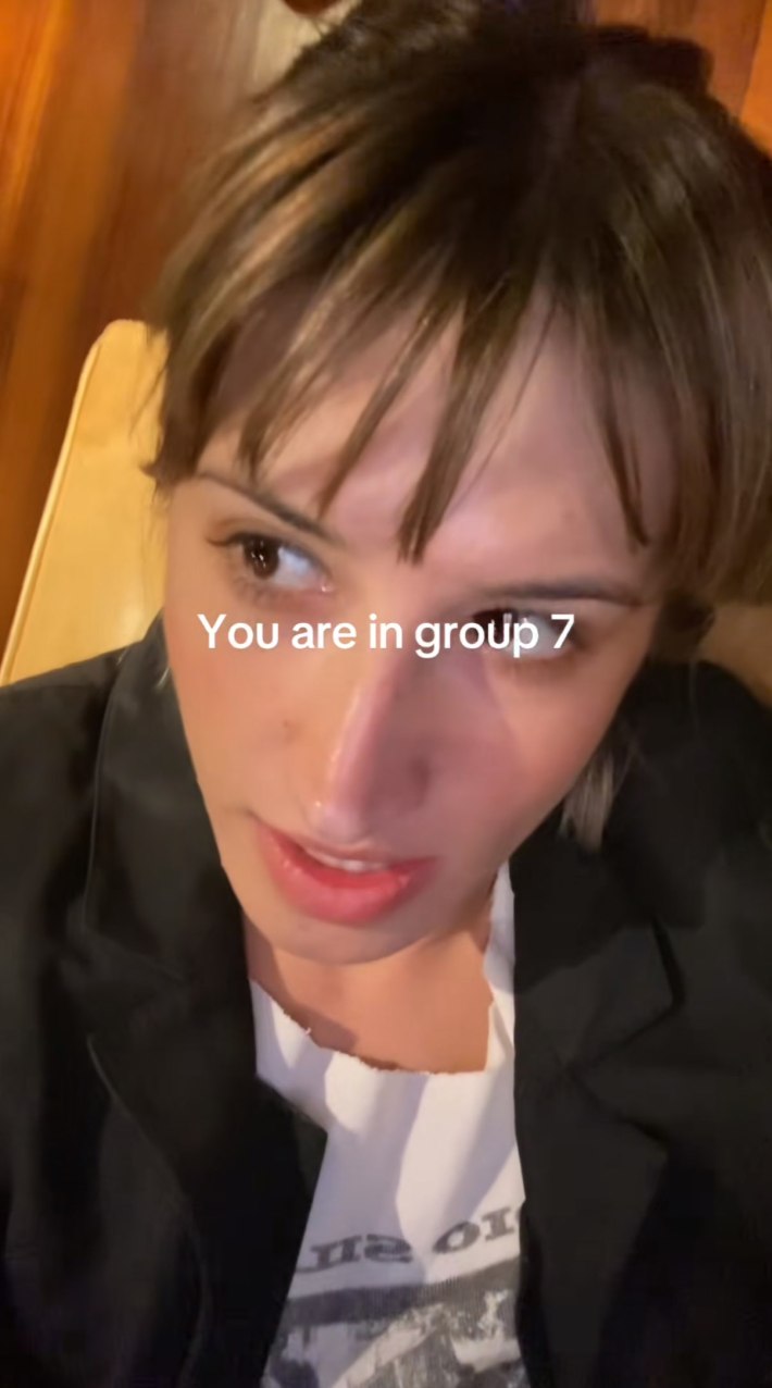 Sophia reclining on the ground, looking off to one side. Text overlay reads, "You are in group 7."