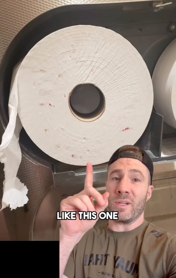 Greenscreen view of a large toilet paper roll with blood marks on it.