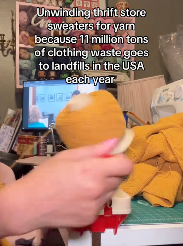 @ourshieldmaiden/TikTok winding a ball of yarn with text "unwinding thrift store sweaters for yarn because 11 million tons of clothing waste goes to landfills in the USA each year."