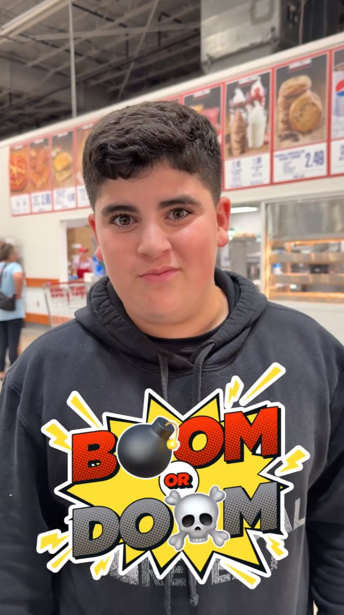 A young man standing in CostCo with the food counter behind him. There is a graphic that says, "Boom or Doom" on the bottom third of the screen.