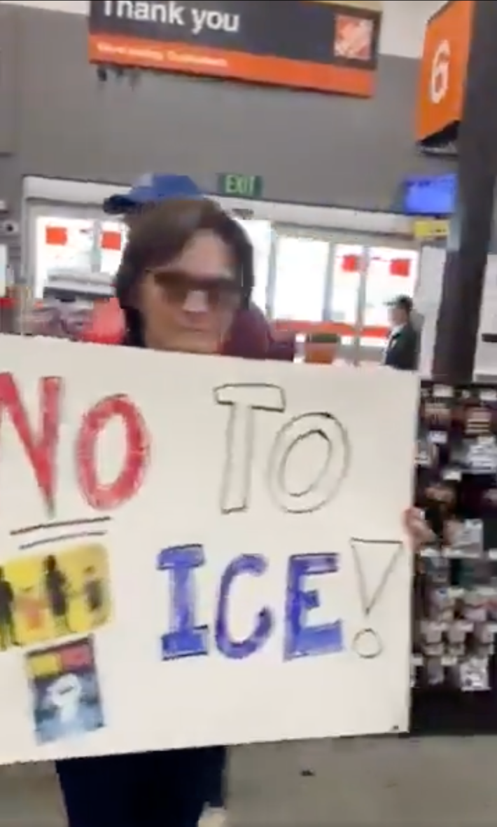 A person holding up a handwritten sign that reads, "No to ICE"