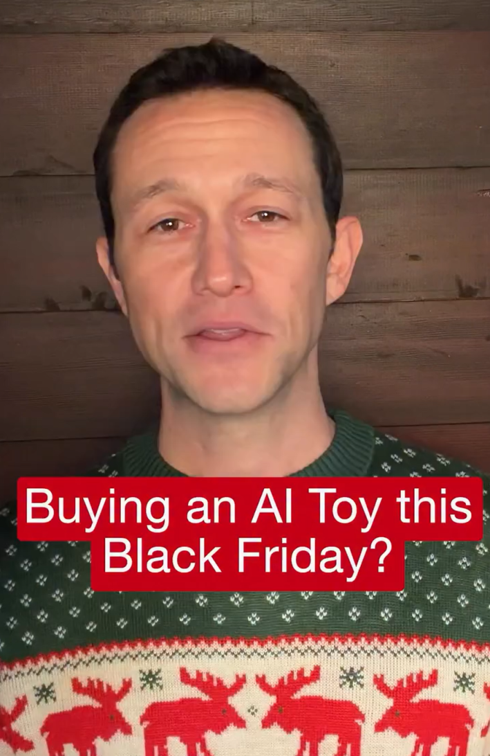 Joseph Gordon-Levitt in a holiday sweater talking to the camera. Text overlay reads, "Buying an AI toy this Black Friday?"